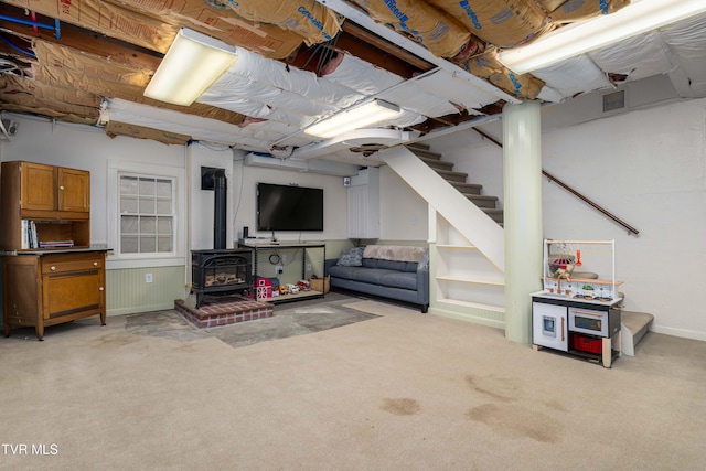 2107 Bartlett St, Johnson City, TN 37601 - below grade area featuring a wood stove, light carpet, stairs, and baseboards