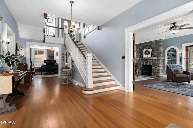 2107 Bartlett St, Johnson City, TN 37601 - stairs with a stone fireplace, wood finished floors, a ceiling fan, a chandelier, and baseboards