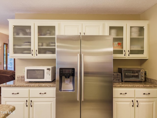 519 Foxgate Dr, Erwin, TN 37650 - kitchen with stainless steel fridge with ice dispenser, white microwave, glass insert cabinets, a textured ceiling, and white cabinetry