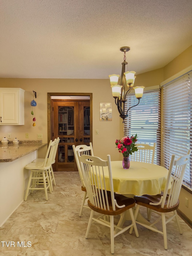 519 Foxgate Dr, Erwin, TN 37650 - dining room with a chandelier, a textured ceiling, and baseboards