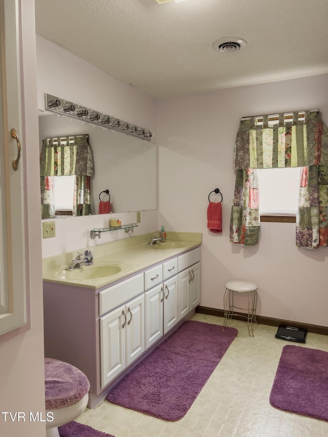 519 Foxgate Dr, Erwin, TN 37650 - bathroom with double vanity, tile patterned floors, baseboards, and a textured ceiling
