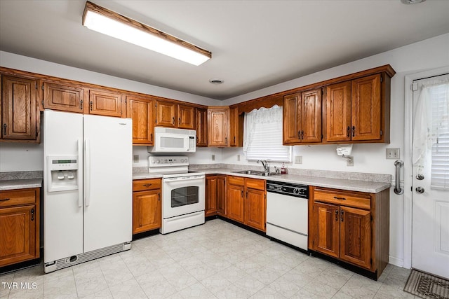 1544 Jessee St Unit Y, Kingsport, TN 37664 - kitchen with white appliances, a sink, brown cabinets, and light countertops