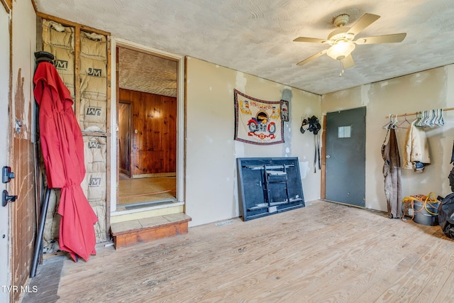 7175 Reedy Creek Rd, Bristol, VA 24202 - living room featuring wood finished floors, ceiling fan, a fireplace, a textured ceiling, and wooden walls