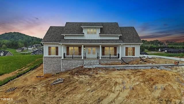 modern inspired farmhouse with french doors, a shingled roof, and a porch