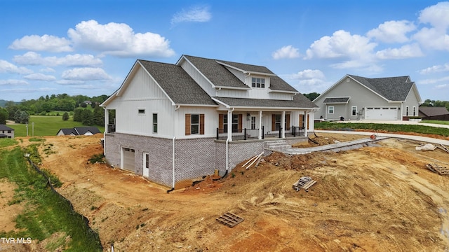 modern farmhouse style home featuring a porch, brick siding, a garage, a shingled roof, and board and batten siding