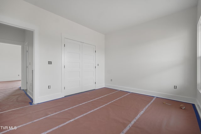 unfurnished bedroom featuring baseboards and a closet