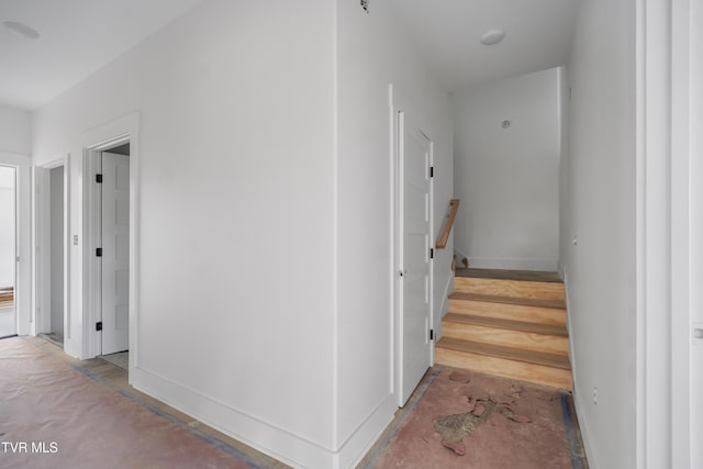 stairs featuring unfinished concrete flooring and baseboards