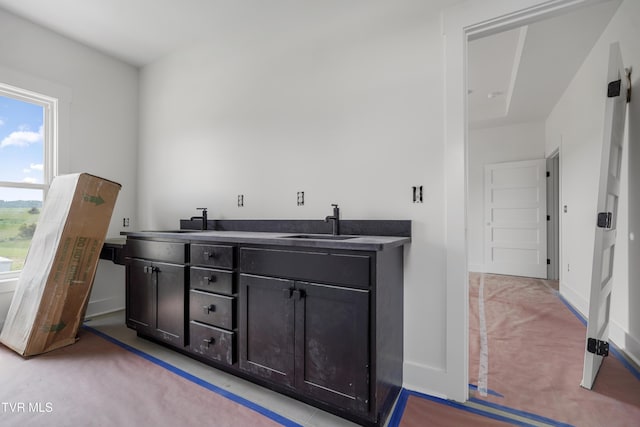 bar with a sink, light colored carpet, and baseboards