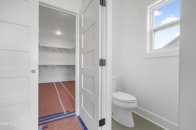 bathroom with baseboards and toilet