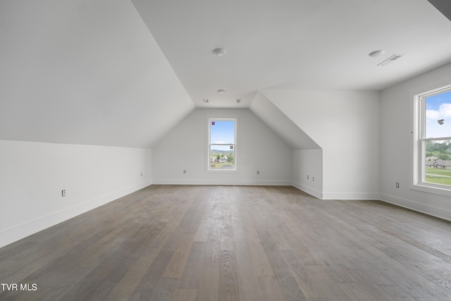 bonus room featuring wood finished floors, vaulted ceiling, and baseboards