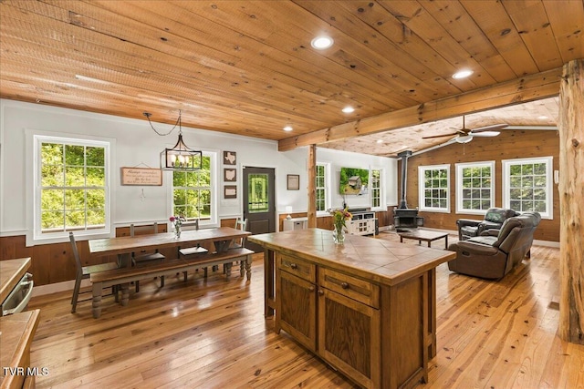 108 Chock Creek Rd, Johnson City, TN 37601 - kitchen featuring tile counters, a wood stove, light wood-style floors, wooden ceiling, and a ceiling fan