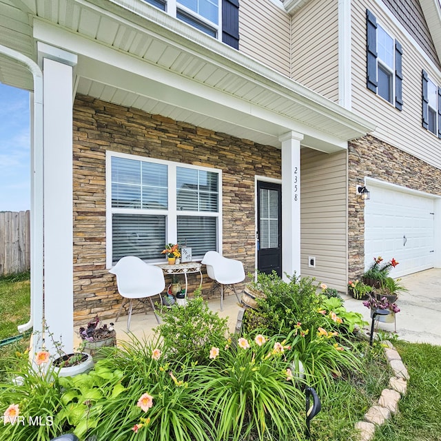 2358 Stream View Ln, Morristown, TN 37814 - view of exterior entry featuring stone siding, covered porch, an attached garage, and concrete driveway