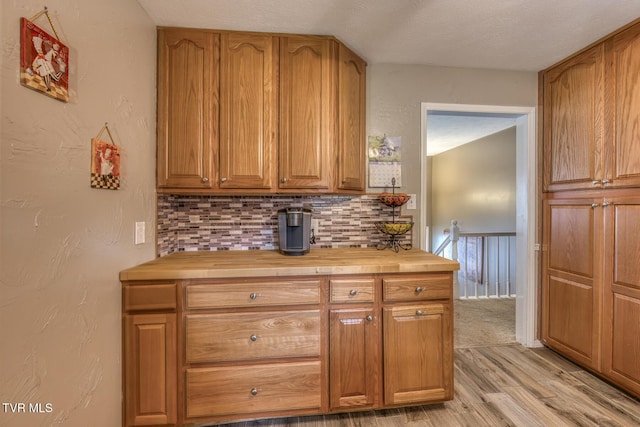 115 Dover Ln, Bristol, TN 37620 - kitchen with butcher block countertops, light wood finished floors, tasteful backsplash, and brown cabinets