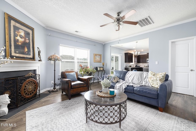 478 Brinkleys Way, Johnson City, TN 37615 - living room with a ceiling fan, a textured ceiling, a chandelier, a fireplace with raised hearth, and ornamental molding