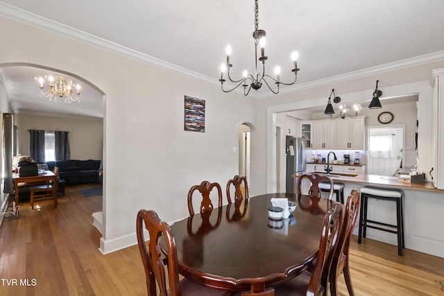 108 S Rogers St, Rogersville, TN 37857 - dining area featuring arched walkways, a chandelier, crown molding, light wood-style floors, and baseboards