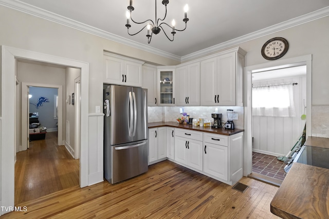 108 S Rogers St, Rogersville, TN 37857 - kitchen with freestanding refrigerator, dark countertops, white cabinets, light wood-type flooring, and ornamental molding