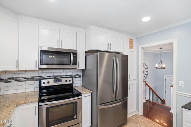 137 Highland Rd, Jonesborough, TN 37659 - kitchen with appliances with stainless steel finishes, decorative backsplash, white cabinetry, light stone countertops, and ornamental molding