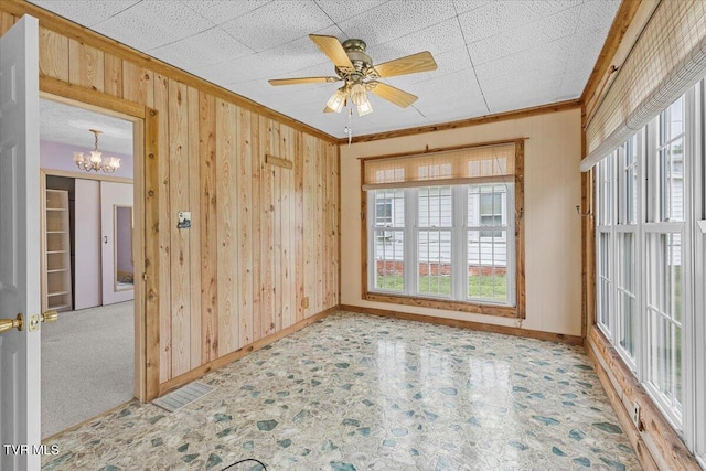 648 Maple Ave, Erwin, TN 37650 - spare room featuring wood walls, ornamental molding, healthy amount of natural light, a chandelier, and baseboards