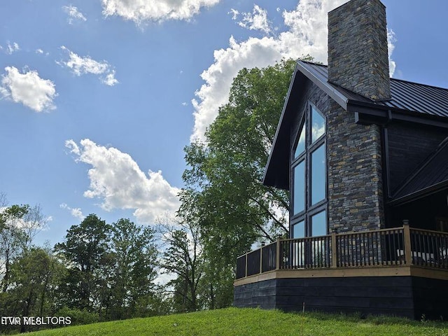 833 Duck Creek Rd, Sneedville, TN 37869 - view of property exterior featuring a chimney, metal roof, a wooden deck, and stone siding