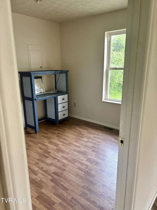 161 Jack Rival Way, Dungannon, VA 24245 - unfurnished bedroom with wood finished floors, multiple windows, a textured ceiling, and baseboards