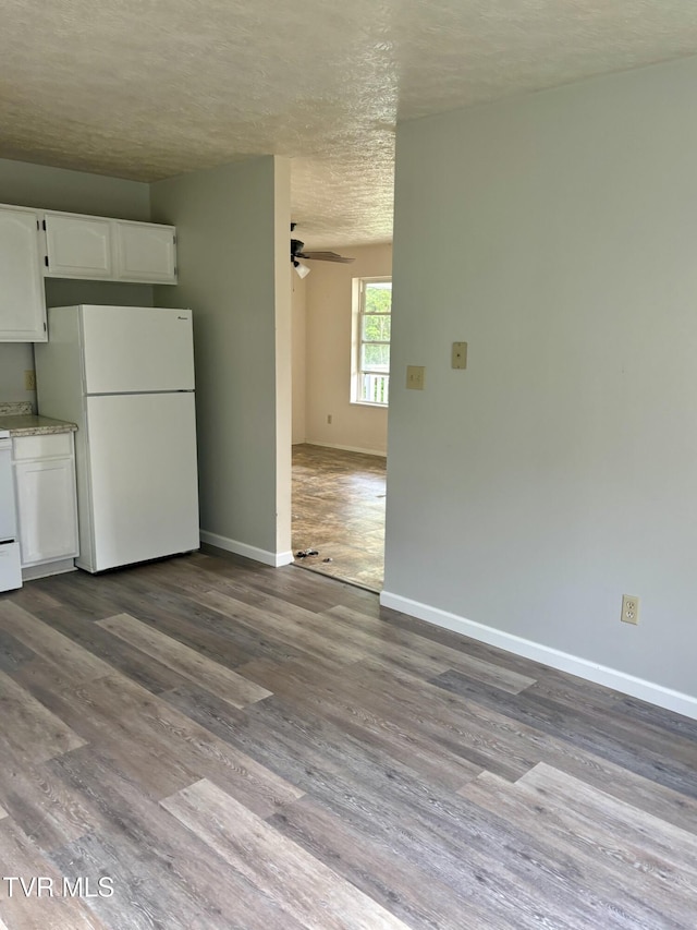 161 Jack Rival Way, Dungannon, VA 24245 - unfurnished dining area with a textured ceiling, a ceiling fan, baseboards, and dark wood-type flooring