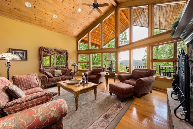 203 Bear Ridge Dr, Butler, TN 37640 - living area featuring high vaulted ceiling, a fireplace with raised hearth, wooden ceiling with exposed beams, light wood finished floors, and a ceiling fan