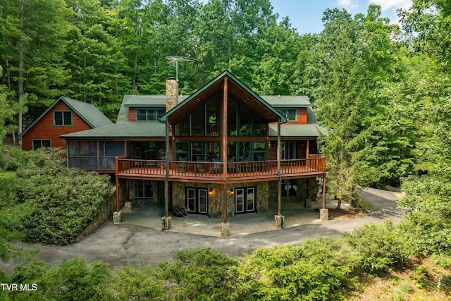 203 Bear Ridge Dr, Butler, TN 37640 - back of property with a chimney, a patio area, a sunroom, stone siding, and a wooden deck
