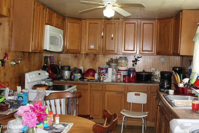 2967 Left Poor Valley Rd, Pennington Gap, VA 24277 - kitchen with white appliances, a ceiling fan, brown cabinets, a sink, and wooden walls