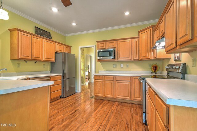 4619 Merrywood Ave, Kingsport, TN 37664 - kitchen with appliances with stainless steel finishes, under cabinet range hood, crown molding, hardwood / wood-style floors, and light countertops