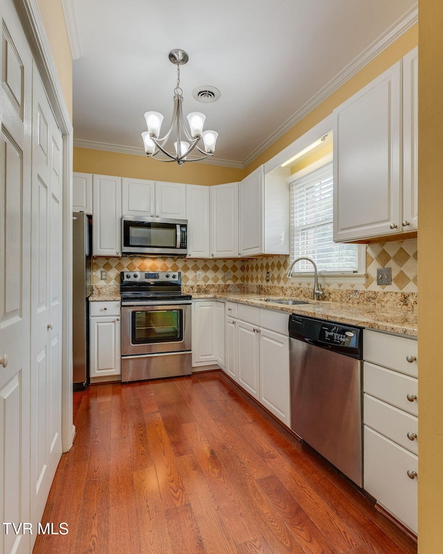 1101 E 8th Ave Unit 5, Johnson City, TN 37601 - kitchen featuring appliances with stainless steel finishes, a sink, a chandelier, white cabinets, and backsplash