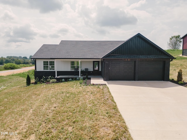 2166 Old Stage Rd, Tusculum, TN 37745 - view of front facade with an attached garage, concrete driveway, board and batten siding, and a front yard