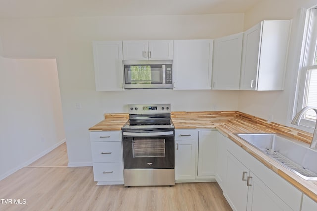 329 Clinch St, Kingsport, TN 37660 - kitchen with appliances with stainless steel finishes, butcher block countertops, a sink, and light wood-style floors