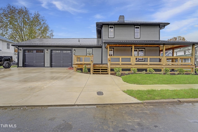403 Catawba St, Erwin, TN 37650 - view of front of house featuring concrete driveway, a garage, a chimney, metal roof, and a porch