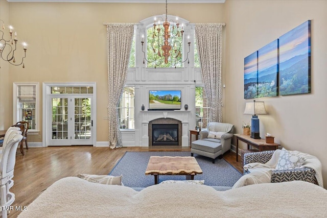 114 Highland Gate Dr, Johnson City, TN 37615 - living room featuring a chandelier, wood finished floors, a towering ceiling, a fireplace with flush hearth, and baseboards