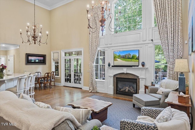 114 Highland Gate Dr, Johnson City, TN 37615 - living room with a chandelier, a fireplace with flush hearth, crown molding, wood finished floors, and a towering ceiling