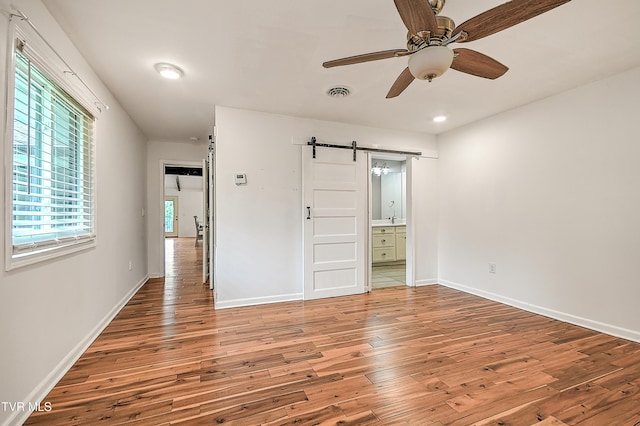 28 Kingsbridge St, Bristol, TN 37620 - unfurnished bedroom featuring a barn door, hardwood / wood-style flooring, baseboards, ensuite bath, and recessed lighting