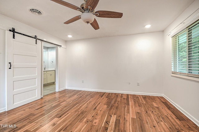 28 Kingsbridge St, Bristol, TN 37620 - spare room featuring a barn door, light wood-style flooring, a ceiling fan, baseboards, and recessed lighting