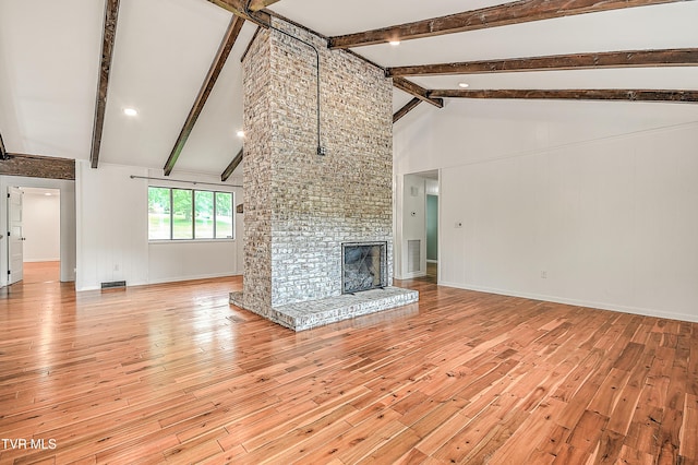 28 Kingsbridge St, Bristol, TN 37620 - unfurnished living room with light wood-type flooring, high vaulted ceiling, beam ceiling, baseboards, and a brick fireplace