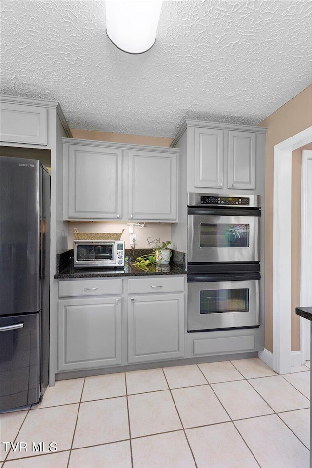124 Highland Hills Dr, Gray, TN 37615 - kitchen with freestanding refrigerator, double oven, gray cabinetry, light tile patterned floors, and a textured ceiling