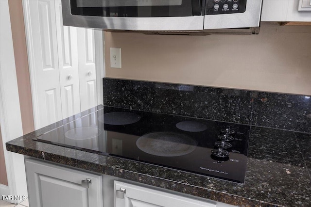 124 Highland Hills Dr, Gray, TN 37615 - kitchen featuring black electric stovetop, white cabinetry, stainless steel microwave, and dark stone countertops