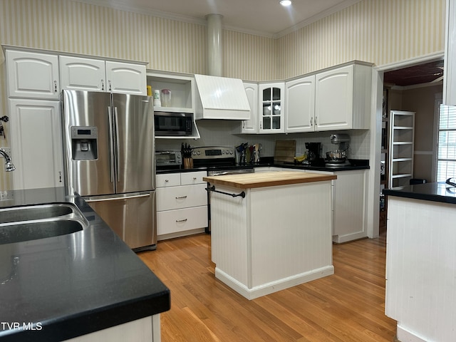 390 Springdale Dr, Bristol, TN 37620 - kitchen with appliances with stainless steel finishes, wood counters, ornamental molding, custom exhaust hood, and light wood-type flooring