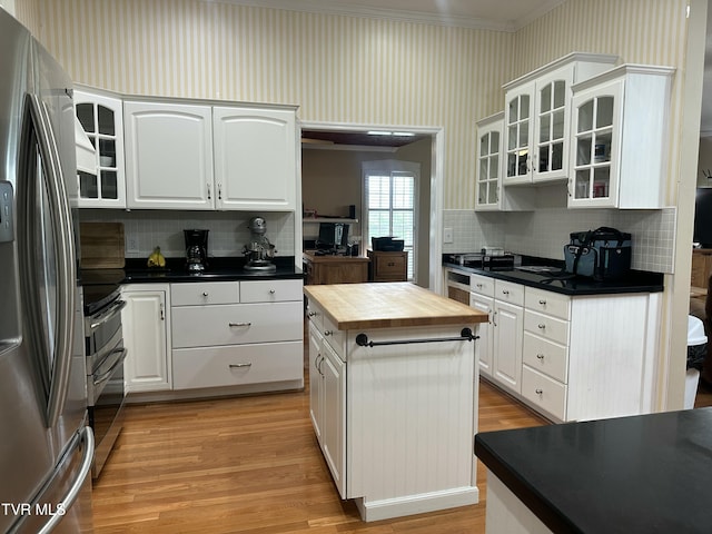 390 Springdale Dr, Bristol, TN 37620 - kitchen with stainless steel appliances, butcher block counters, ornamental molding, decorative backsplash, and glass insert cabinets