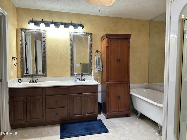 390 Springdale Dr, Bristol, TN 37620 - bathroom featuring tile patterned flooring, a freestanding bath, a textured wall, double vanity, and a textured ceiling