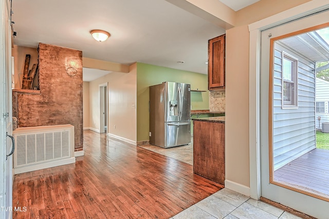 1401 Burgie St, Elizabethton, TN 37643 - kitchen with stainless steel fridge with ice dispenser, baseboards, dark countertops, brown cabinetry, and backsplash