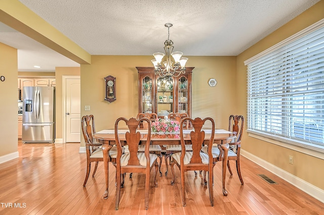 105 Morse Dr, Bristol, TN 37620 - dining room with a chandelier, light wood-style flooring, baseboards, and a textured ceiling