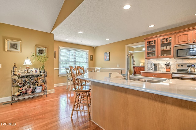105 Morse Dr, Bristol, TN 37620 - kitchen with stainless steel appliances, a sink, light wood-style flooring, backsplash, and glass insert cabinets