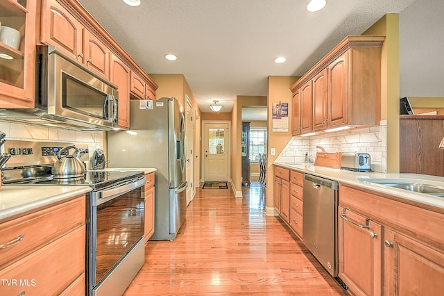105 Morse Dr, Bristol, TN 37620 - kitchen with appliances with stainless steel finishes, light countertops, glass insert cabinets, backsplash, and light wood-style floors