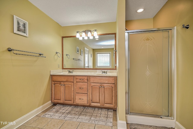 105 Morse Dr, Bristol, TN 37620 - full bathroom featuring a textured ceiling, a shower stall, baseboards, double vanity, and tile patterned flooring