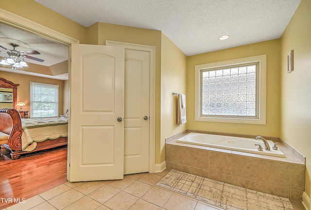 105 Morse Dr, Bristol, TN 37620 - ensuite bathroom with a textured ceiling, tile patterned flooring, a bath, a ceiling fan, and baseboards