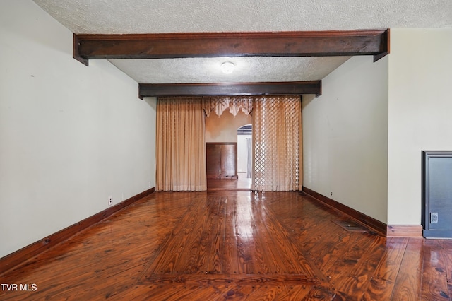 11316 Boggs Hollow Rd, Pound, VA 24279 - empty room with beamed ceiling, a textured ceiling, hardwood / wood-style flooring, and baseboards